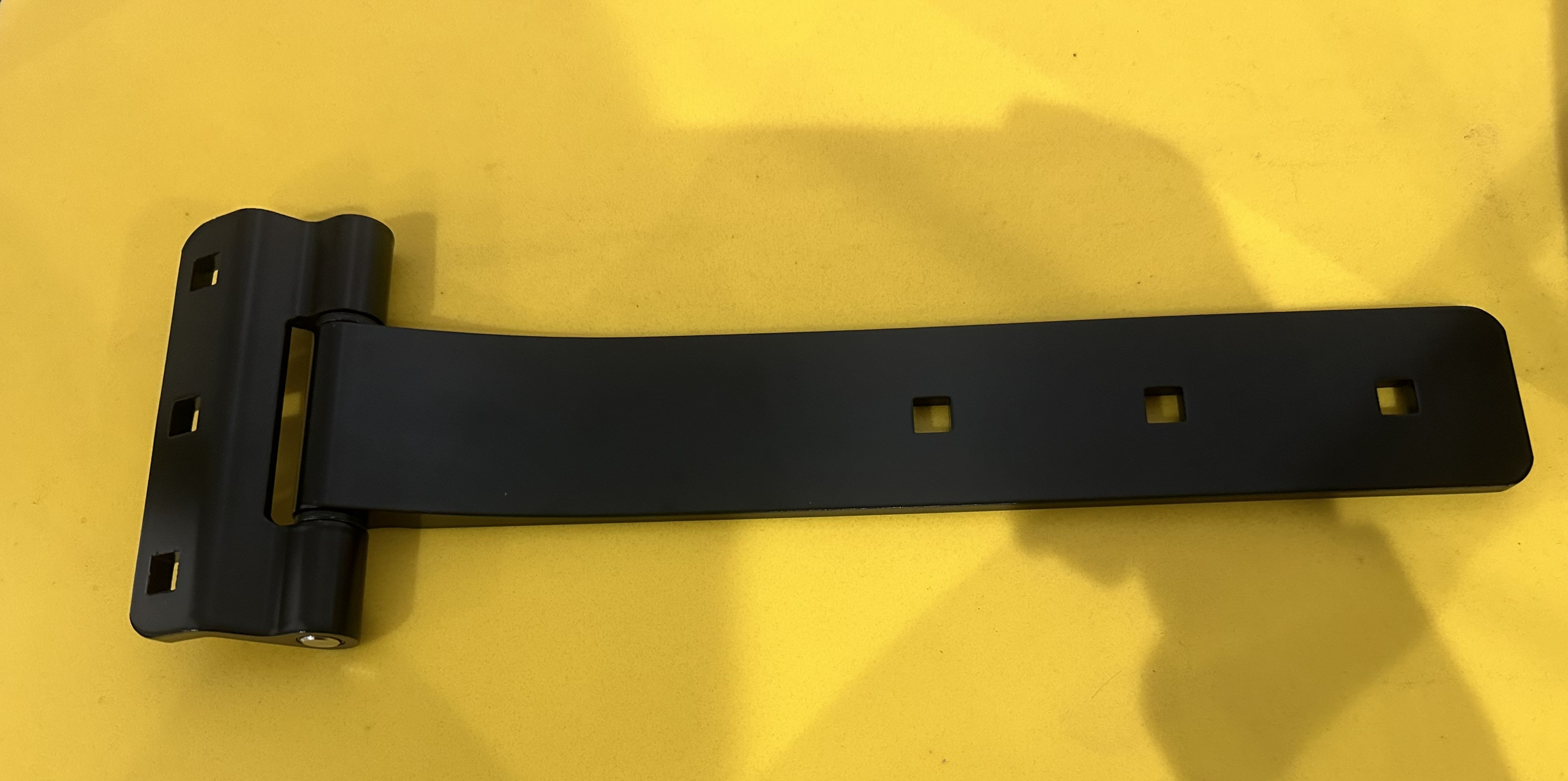 Black aluminum strap hinge for trailer body and frame, durable component from Indiana Trailer Sales.