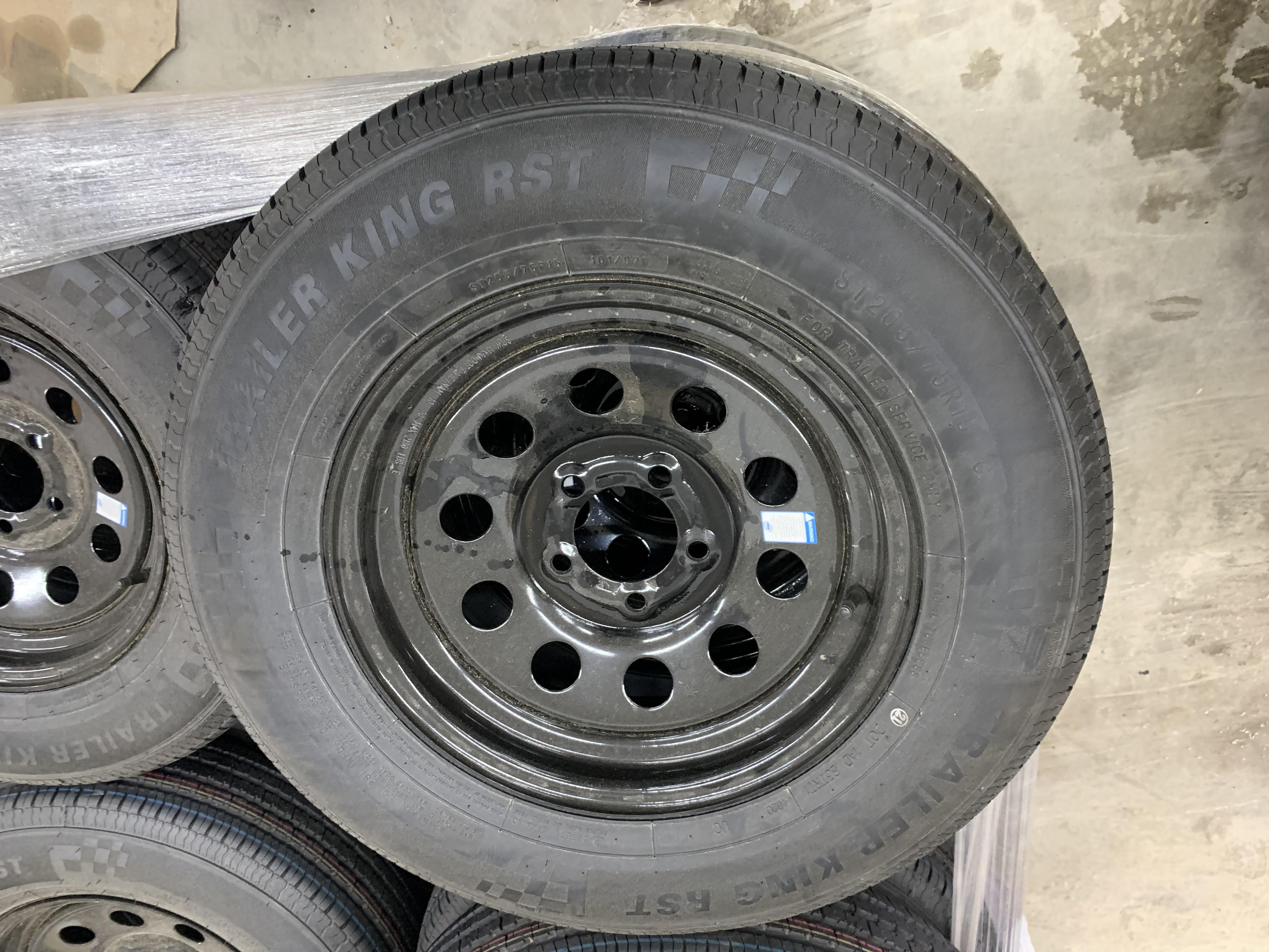 Black ST205/75R15 Discovery Cargo Trailers Mod tire mounted on wheel, showcasing rugged tread and sidewall design.