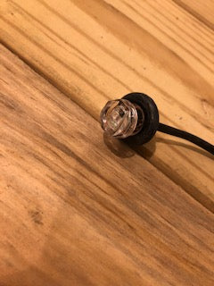 Red and clear LED indicator light from Tex Trail with two diodes and protective grille, mounted on a black electrical component.