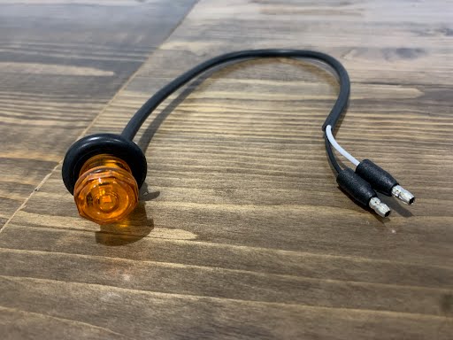 Tex Trail LED 3/4 round amber marker light for electrical and lighting applications, showing the illuminated amber lens.