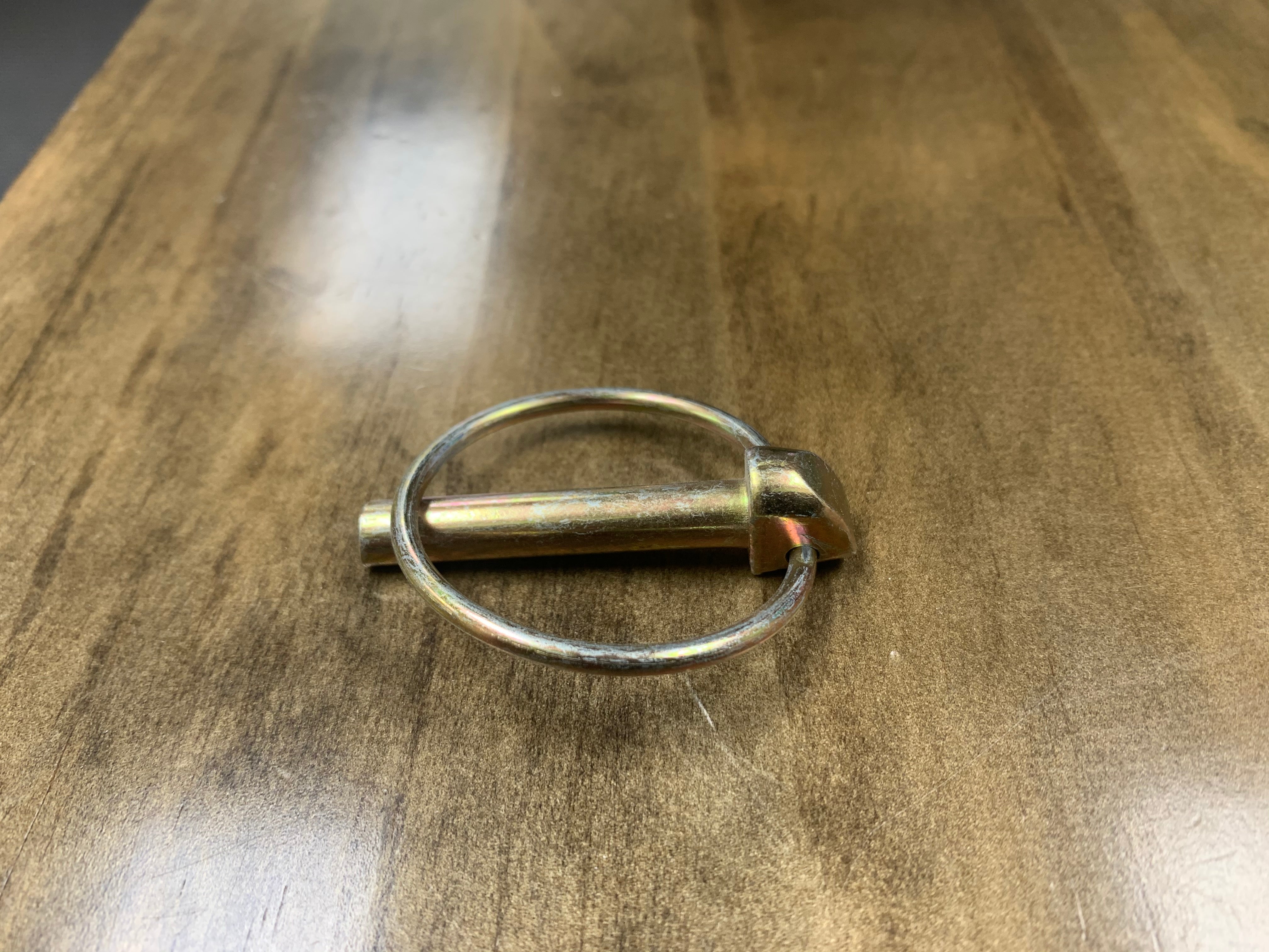 Yellow zinc PIN LINCH trailer lock by Tex Trail, 5/16x1-3/4 inch, for securing trailer accessories and equipment.